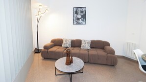 A modern living room with a brown sofa, a round coffee table, and a floor lamp. - Modern Parisian Apartment Center of Paris (Paris)