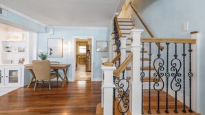 A staircase with white columns and black balusters, leading to a second floor.