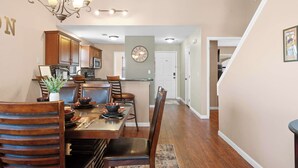 A dining area with a wooden table, chairs, and a chandelier. - Branson Blessing Condo for 8! (Branson)