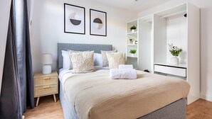 Ein modernes Schlafzimmer mit Bett, Nachttischen und einem Einbauschrank.