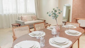 A dining area with a wooden table set for four, surrounded by wicker chairs. - Elegant Apartment St Germain des Pres Luxembourg Park (Paris)