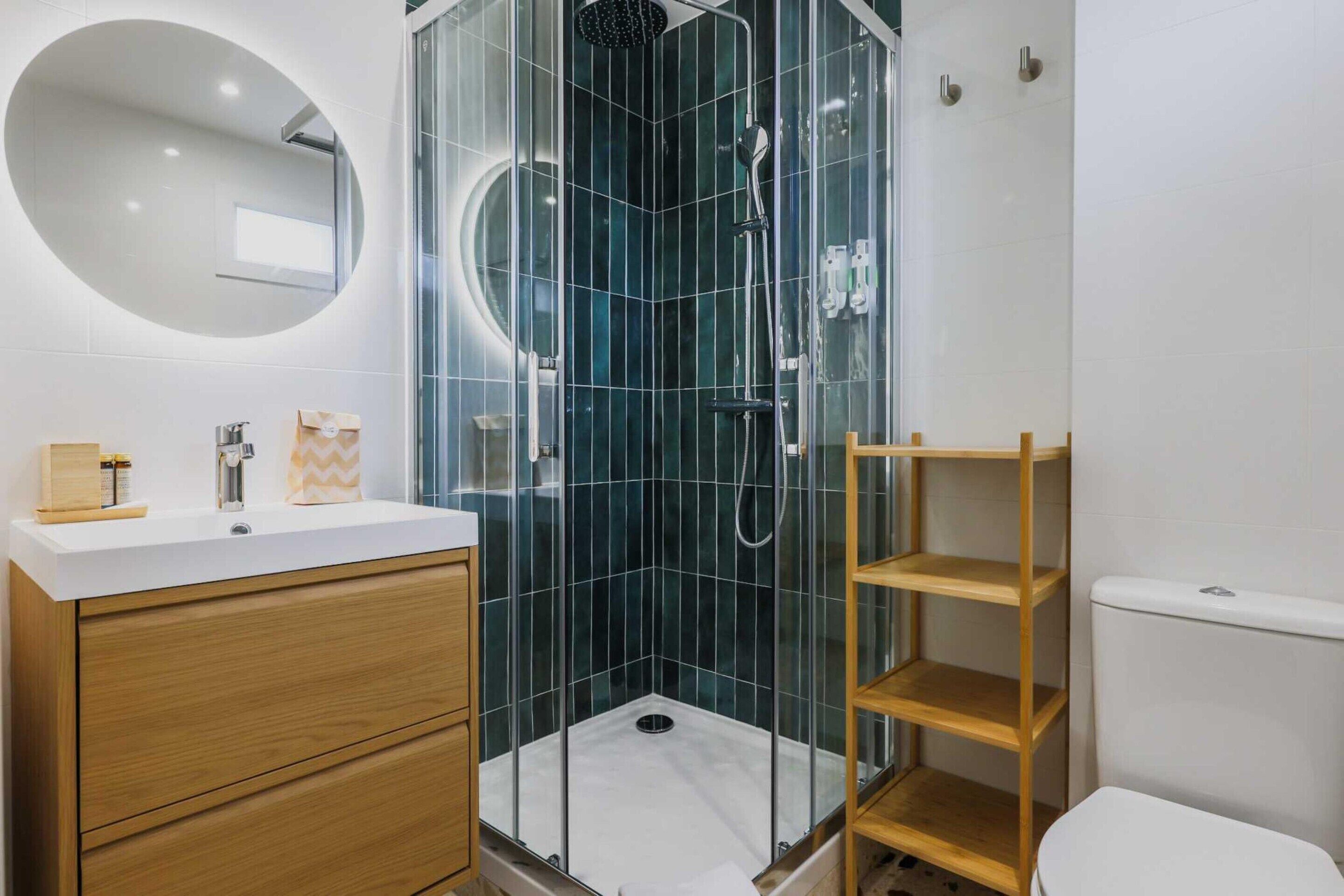 Une salle de bain moderne avec une douche à parois de verre, un meuble-lavabo en bois et des toilettes blanches.