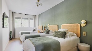 A hotel room with two beds, a window with curtains, a bedside table with a lamp, and a wall-mounted light fixture. - Modern "green Suites" Residence - Meudon/velizy (Meudon)