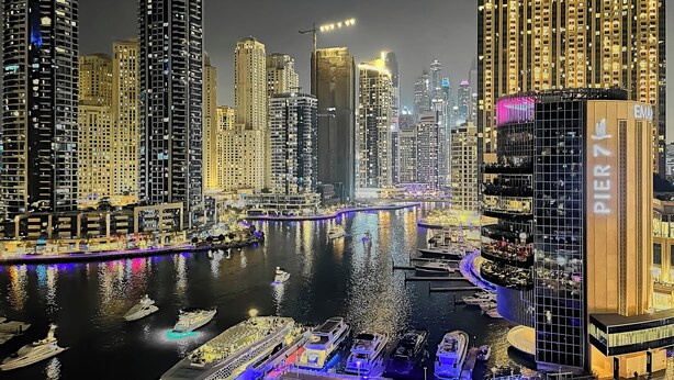 A high-rise building with a prominent "Pier 74" sign, surrounded by water and other high-rise buildings.