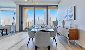 A modern dining area with a city view, a sofa, and a dining table set for six. - bnbme | Burj Vista Tower 1 | 3 + Maids (Dubai)