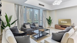 Ein modernes Wohnzimmer mit einer großen Sofagarnitur, einem Couchtisch und einem Flachbildfernseher.