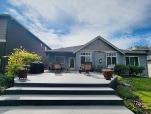 A residential house with a covered patio, outdoor seating, and a well-maintained lawn. - Golf Course home sleeps 6 (Port Orchard)