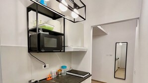 Une cuisine moderne équipée d’un four à micro-ondes encastré, d’un évier et d’un plan de travail sur lequel sont disposés divers objets.