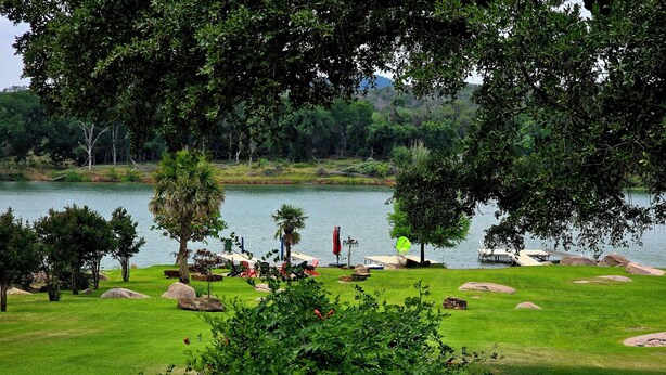 Un parc au bord du lac, avec des pelouses, des arbres et une jetée.