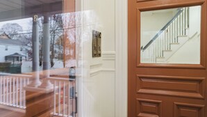 Una puerta de madera con un panel de vidrio, un buzón y un número de casa.