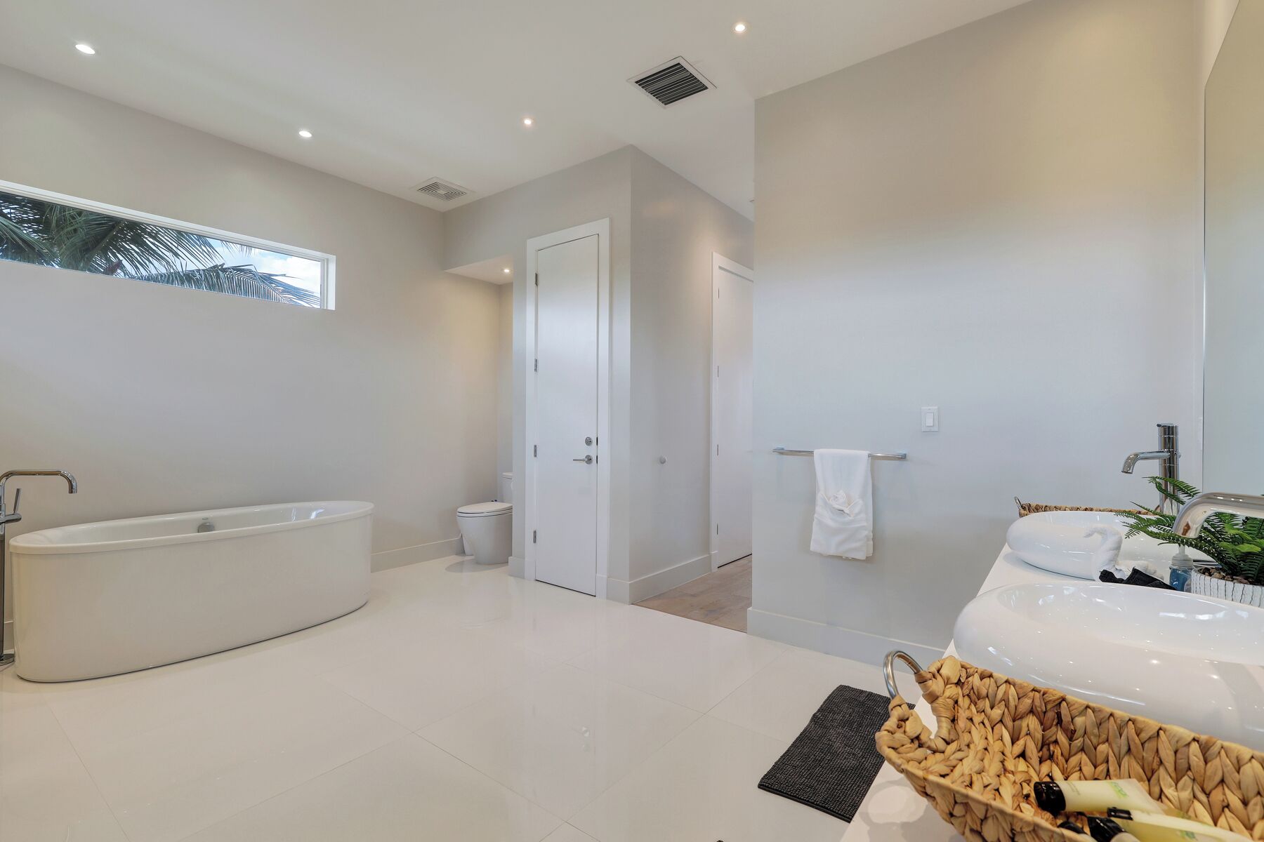 Et moderne badeværelse med badekar, toilet og håndvask.