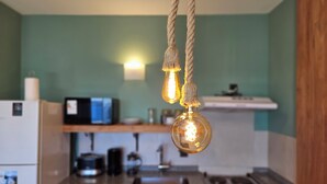 Une cuisine avec un mur vert, des meubles en bois, un four à micro-ondes et une cuisinière.