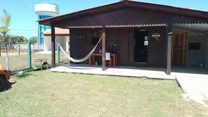 A small, single-story building with a porch and a hammock. - Nice house, one block from the sea.  (Arroio do Sal)