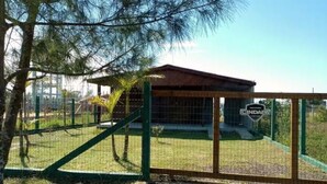 A fenced area with a small building, possibly a restroom or storage shed, and a sign that reads "INDUSTRIA." - Nice house, one block from the sea.  (Arroio do Sal)