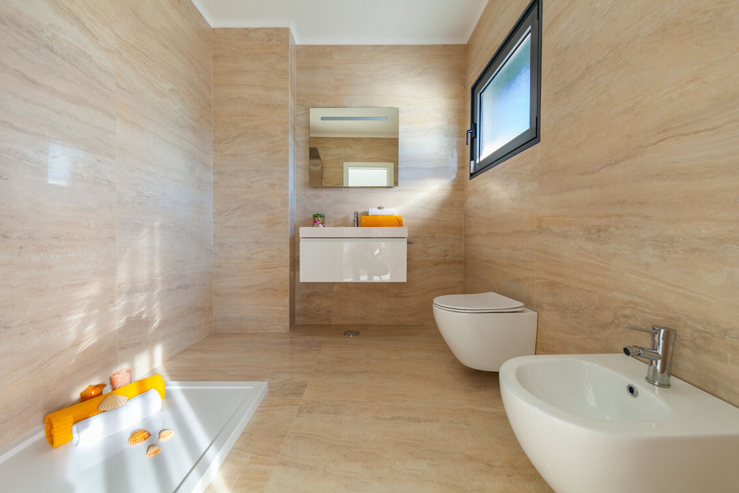 A modern bathroom with a bathtub, a sink, and a toilet.