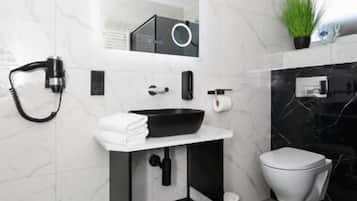 Ein modernes Badezimmer mit einem schwarzen Waschbecken, weißen Marmorwänden, einem grünen Teppich und einer Toilette.