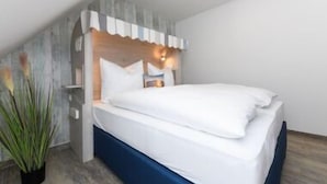 Ein modernes Schlafzimmer mit einem Bett, einem Nachttisch und einer Wandleuchte.