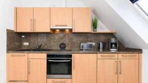 Una cucina moderna con mobili in legno, forno a incasso, microonde e macchina da caffè.