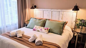 Ein ordentlich bezogenes Bett mit Kissen, ein Nachttisch mit Lampe und eine dekorative Vase.
