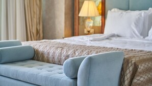 Une chambre d’hôtel avec un lit, un canapé, une lampe et une fenêtre avec des rideaux.