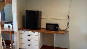 A kitchenette with a refrigerator, microwave, and a wooden countertop. - Apple Valley Motel (Apple Valley)
