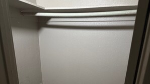 A small, enclosed bathroom with white walls and marble flooring. - Apple Valley Motel (Apple Valley)