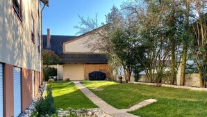 A residential property with a well-maintained lawn, a pathway leading to the house, and a covered barbecue area. - Hotel Franken (Forchheim)