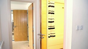 Ein Korridor mit einer Holztür und einer gelben Tür mit einem Streifenrollo.