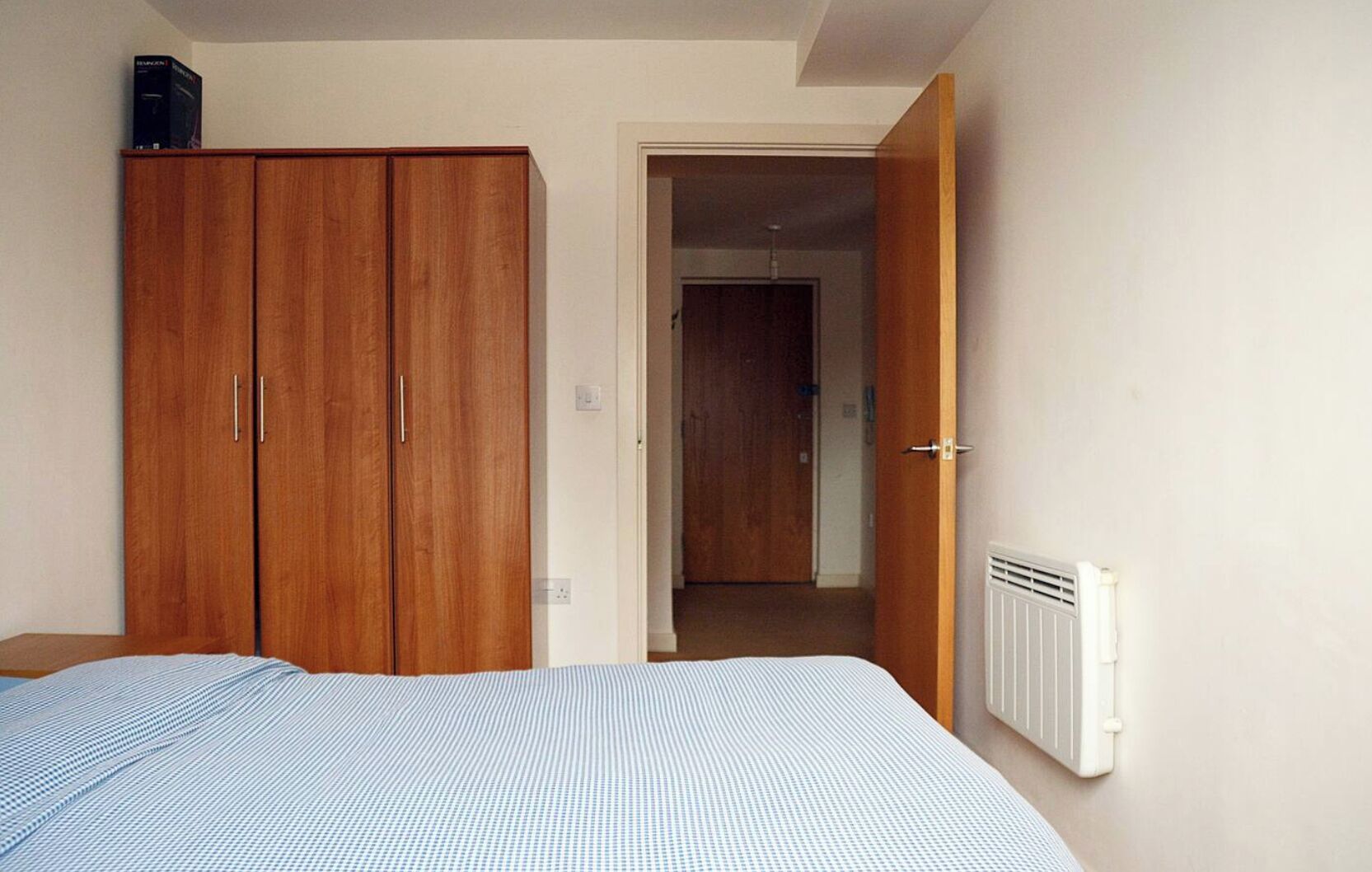 Een slaapkamer met een bed, een kledingkast en een radiator.