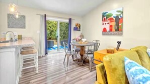 Eine moderne Küche mit Essbereich, einem großen Fenster und einem Gemälde an der Wand.