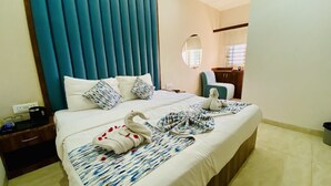 A hotel room with a large bed, a nightstand, a mirror, and a view of the kitchen. - Hotel One Stay (Indore)