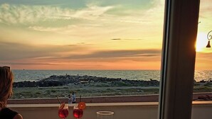 A table with a tablecloth, a candle, and a glass of water.