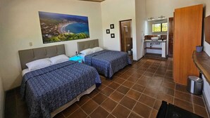 A hotel room with two beds, a bathroom, and a view of a coastal landscape. - Hotel Nica Valley (Rivas)