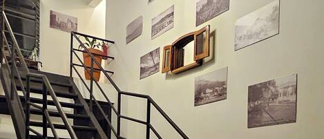 A staircase with metal railings and potted plants, leading to a higher floor.