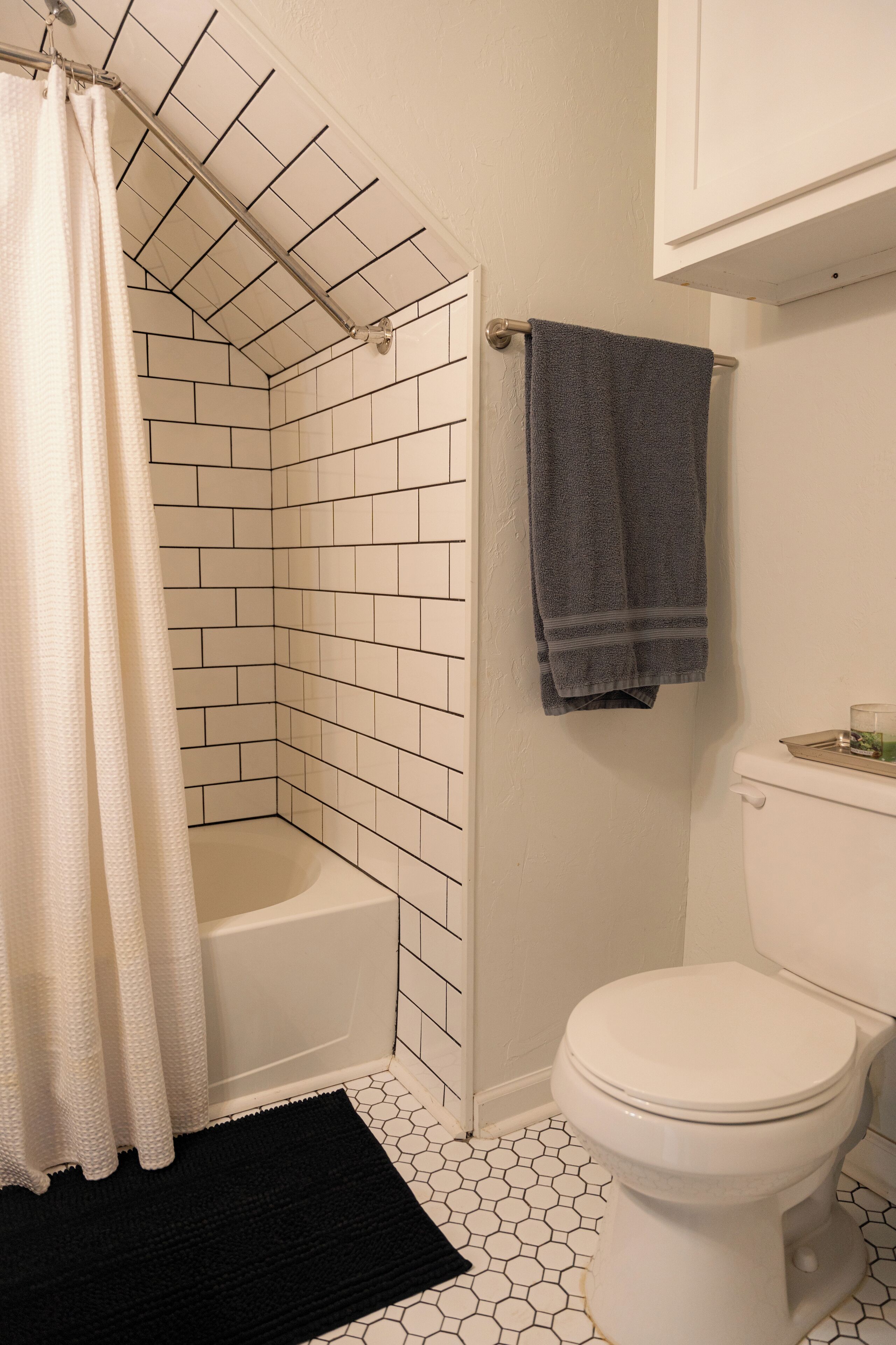 Un baño con ducha, inodoro y perchero para toallas.