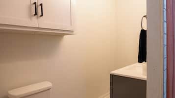 Un baño con inodoro, lavamanos y armarios.
