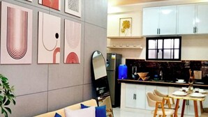 A modern living room with a sofa, coffee table, and artwork on the wall. - Francheska Suite: Minimalist Comfort Near Cavinti’s Natural Wonders (Cavinti)