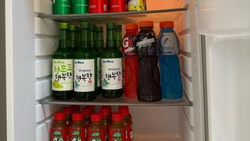 Et køleskab fyldt med forskellige drikkevarer, herunder Red Horse øl, San Mig Light øl, Sprite, Coca-Cola, Del Monte ananasjuice, So Nice grønne druesaft, So Nice original grønne druesaft, Gatorade og C2 grøn te.