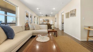 A spacious living room with a sofa, coffee table, and a dining area. - Hawk's View- Mountain Cottage! (Jasper)