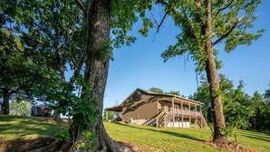A two-story building with a covered porch and a staircase leading to the upper floor. - Hawk's View- Mountain Cottage! (Jasper)