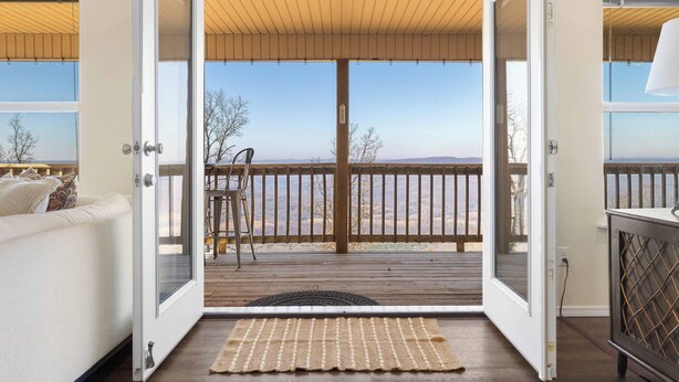 An open door leading to a deck with a view of a distant landscape. - Hawk's View- Mountain Cottage! (Jasper)