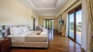 Ampia camera da letto con un letto grande, un comodino, una TV e un balcone con tende.