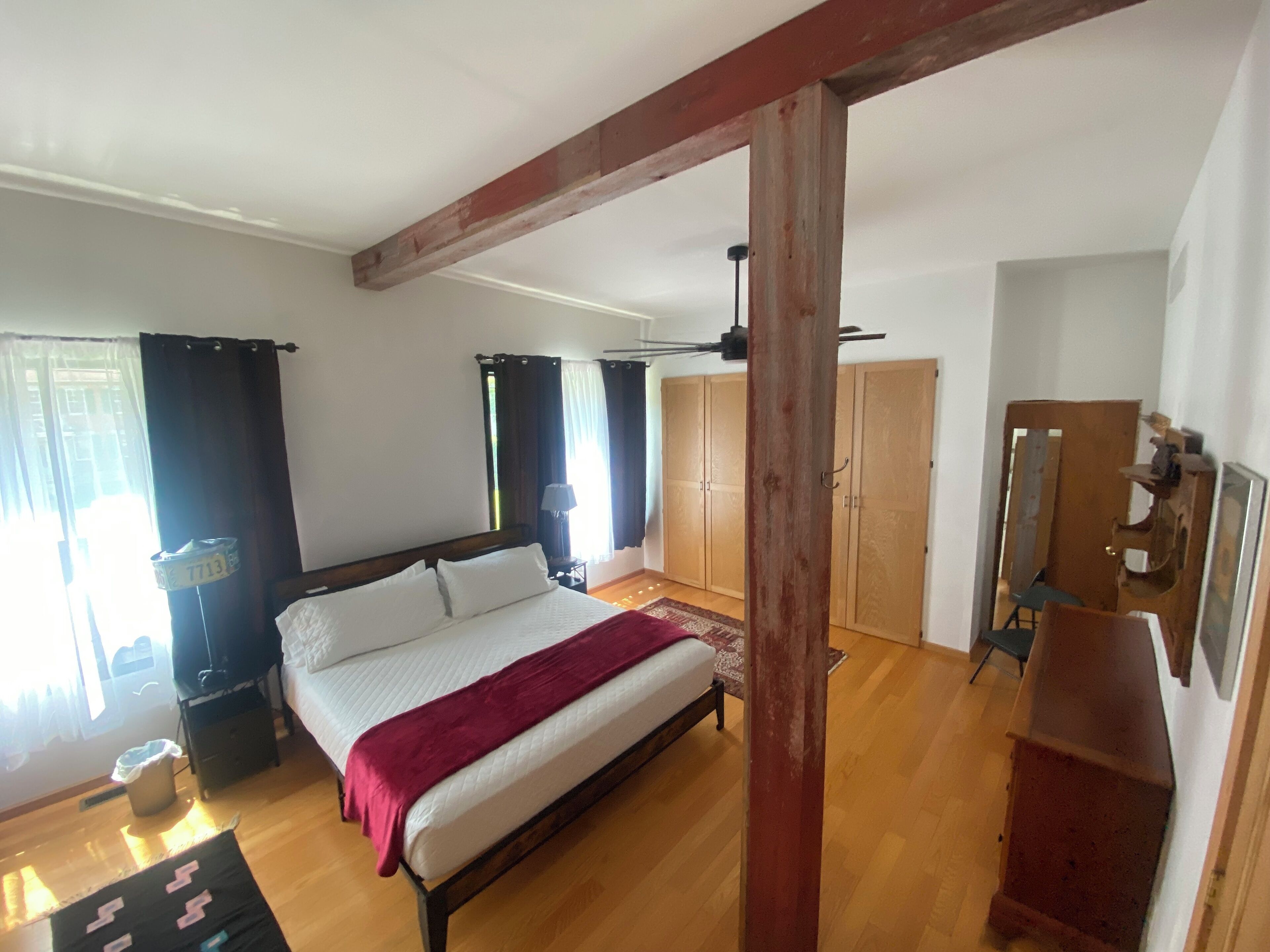 Une chambre à coucher avec un lit en bois, une armoire et un bureau.