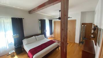 Une chambre à coucher avec un lit en bois, une armoire et un bureau.