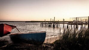 A boat docked at a pier with a clear view of the water and distant shoreline. - The Fisherman's Porch (Bergrivier)