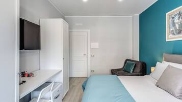 Une chambre à coucher moderne avec un lit, un bureau, une chaise et un téléviseur.
