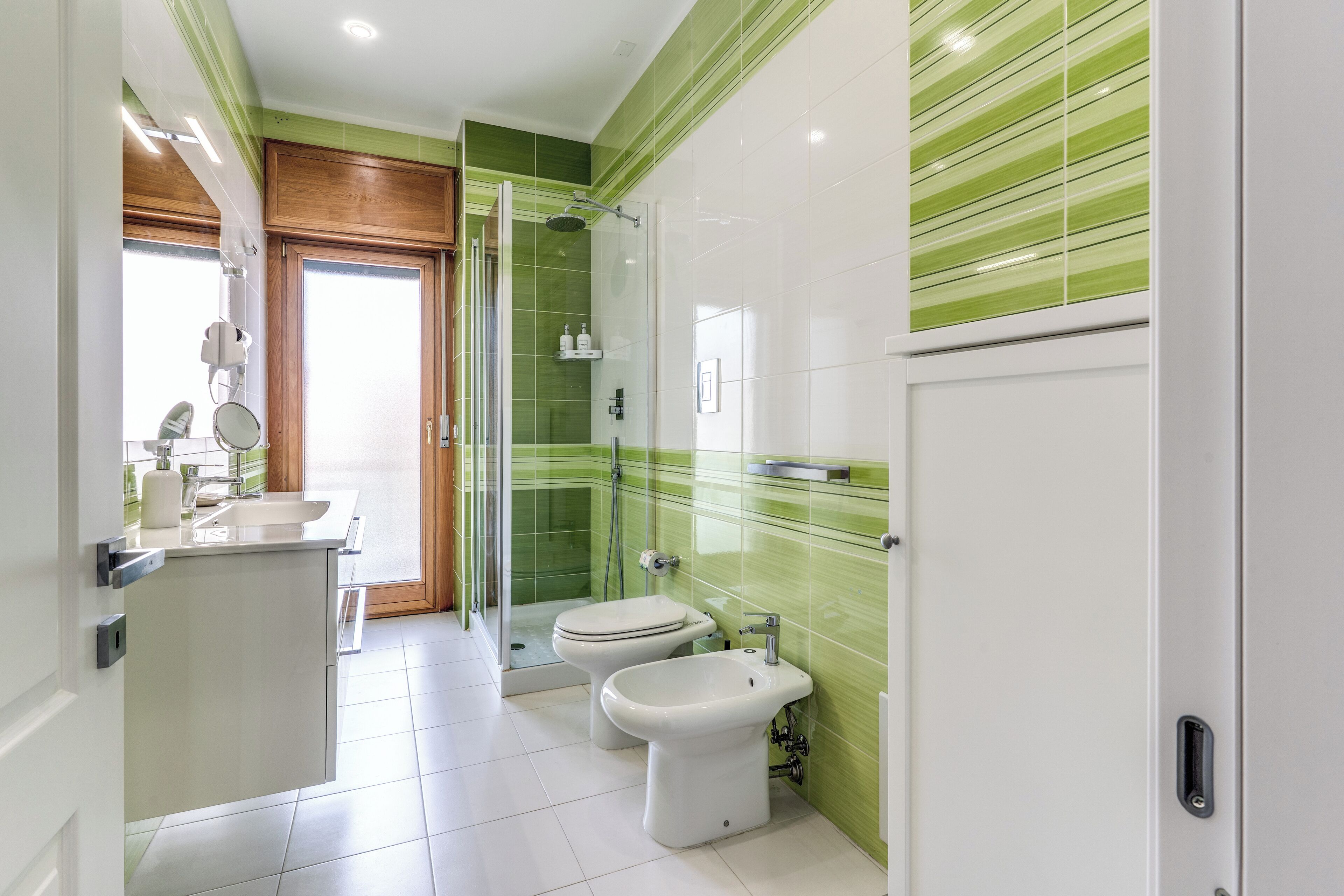 A modern bathroom with a shower, toilet, and sink.