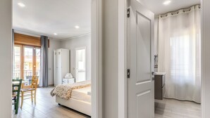 A modern bedroom with a bed, a wardrobe, and a bathroom with a shower curtain. - Marmolo Room (Naples)
