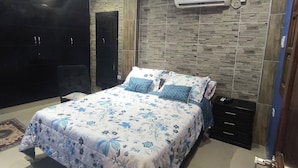 A bedroom with a bed, a ceiling fan, an air conditioning unit, a wardrobe, and a nightstand. - Castle house (Cartagena)