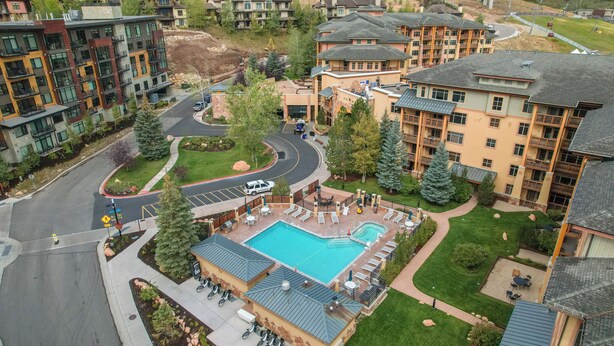 A residential area with modern apartment buildings, a swimming pool, and a landscaped courtyard.